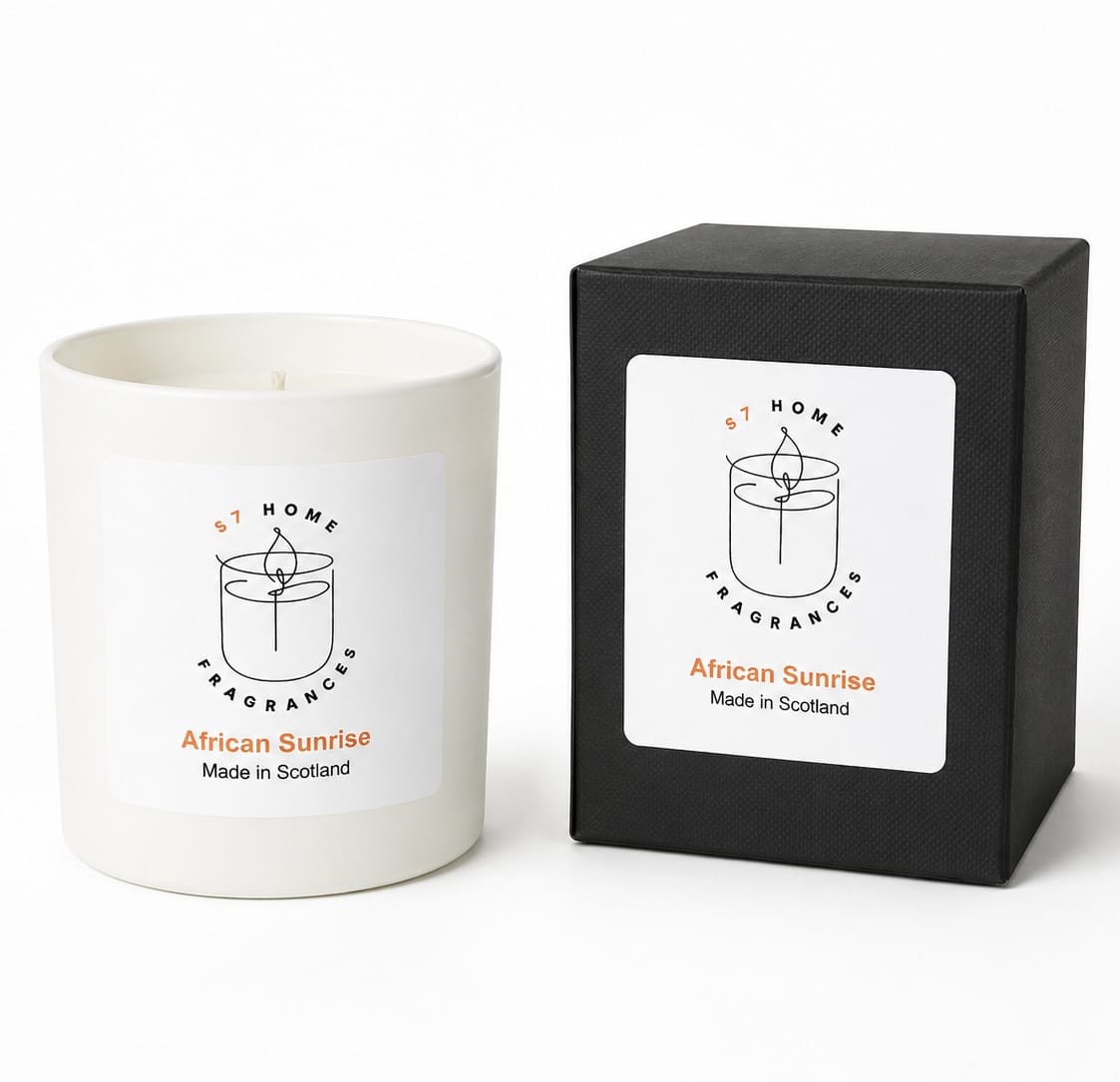 A white wax candle jar next to its black square packaging box, both featuring a white label with the brand name 'S7 Home Fragrances' and the scent 'African Sunrise'.