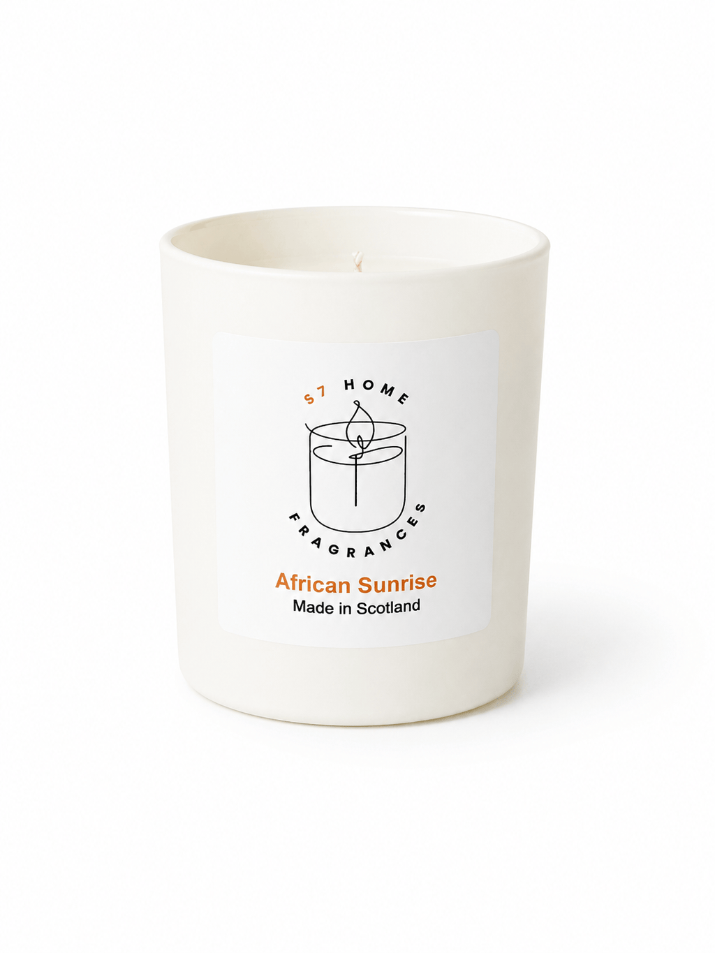 A white wax candle in a matte white glass jar with a white rectangular label. The label features a black line drawing of a candle, the text 'S7 HOME FRAGRANCE', and 'African Sunrise Made in Scotland' in black and orange.