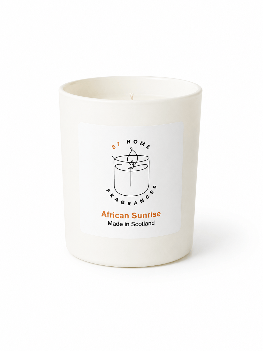 A white wax candle in a matte white glass jar with a white rectangular label. The label features a black line drawing of a candle, the text 'S7 HOME FRAGRANCE', and 'African Sunrise Made in Scotland' in black and orange.