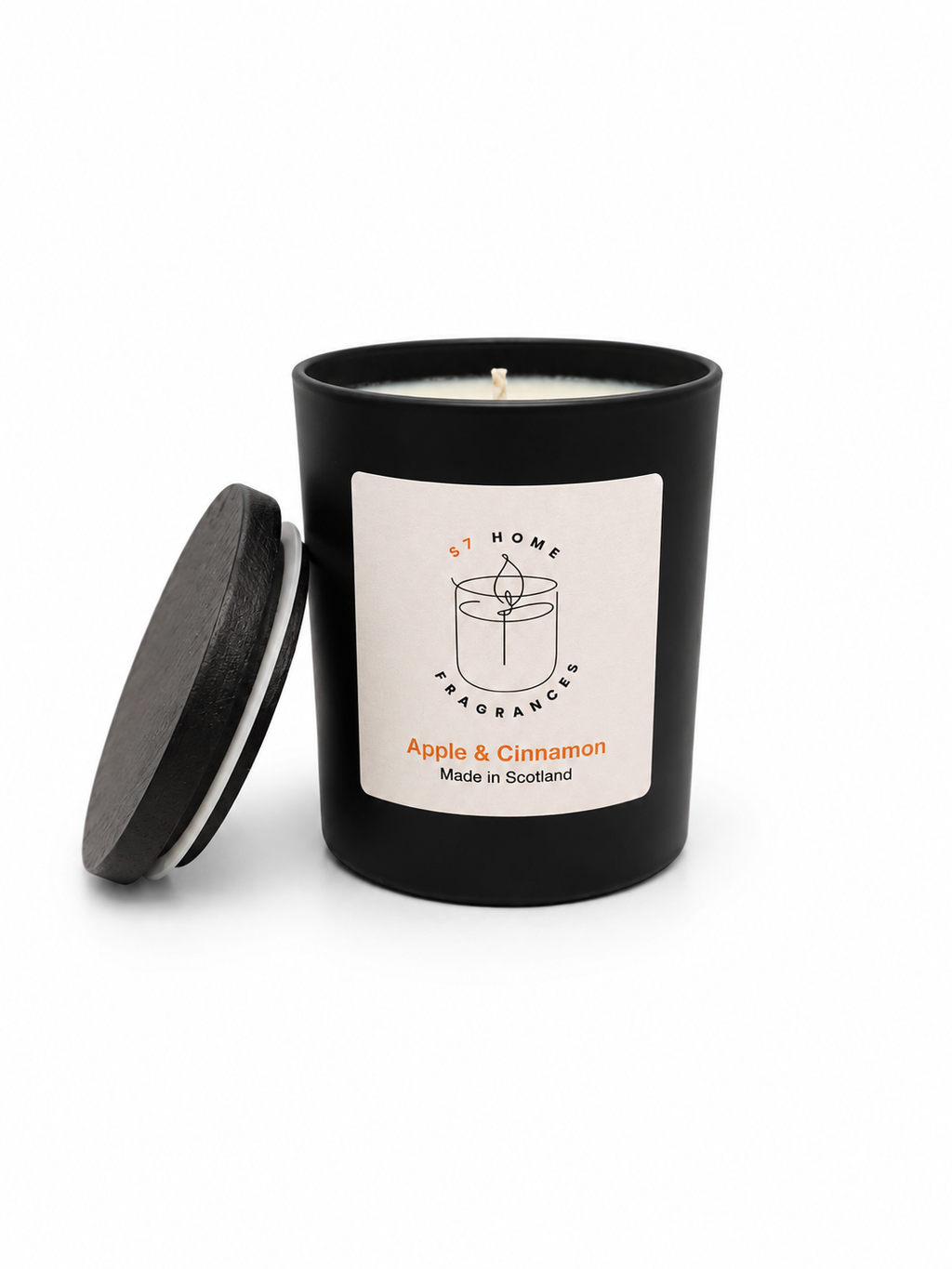 Apple & Cinnamon candle in a black jar with a white label and black wooden jar topper on a white background