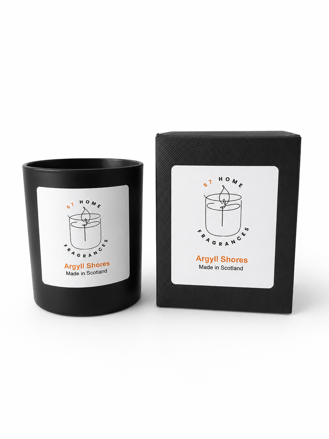 A black glass candle jar with a white label next to its matching black box packaging, both featuring the 'Argyll Shores' scent name and a simple candle line drawing.