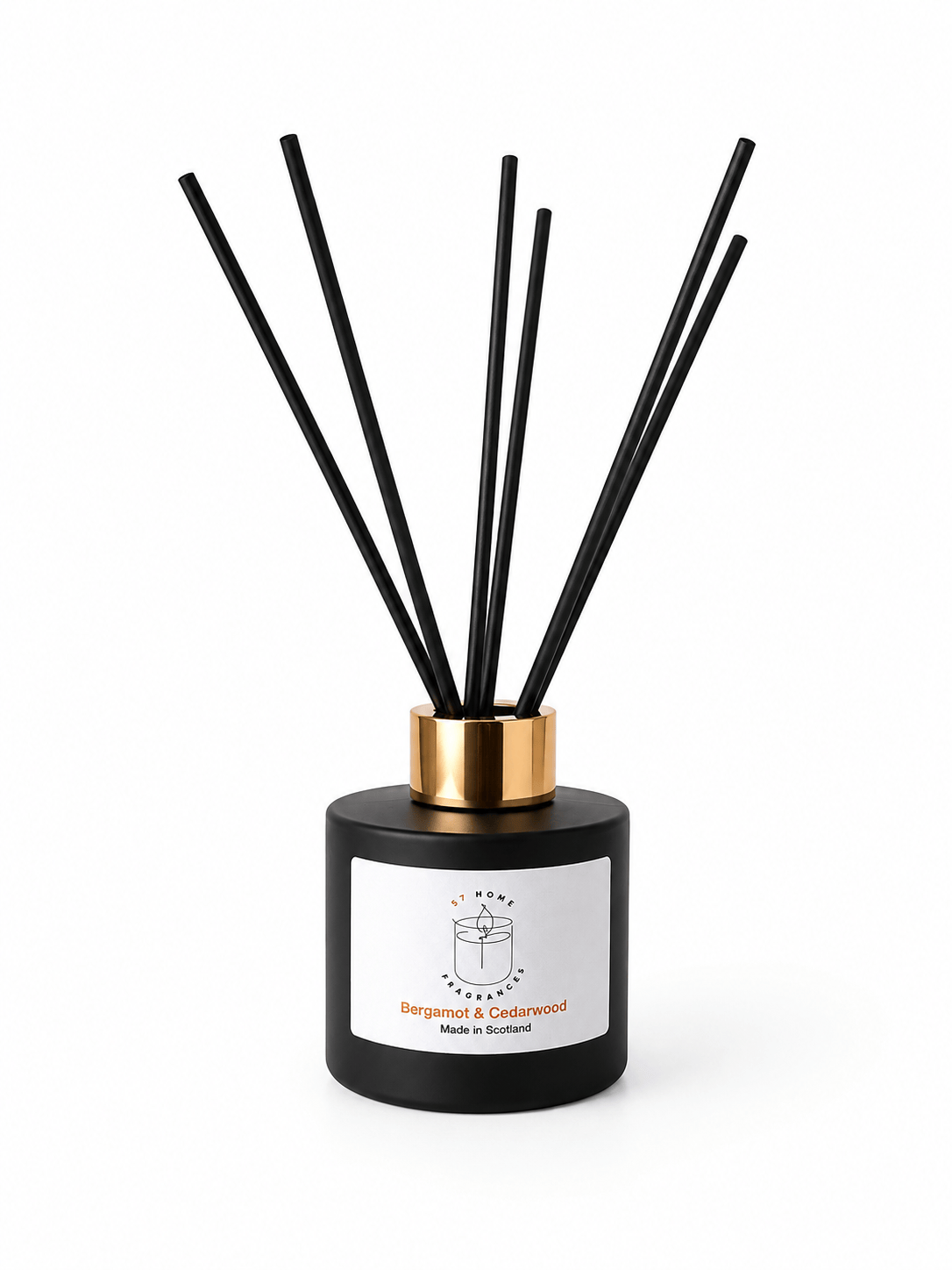 A reed diffuser bottle with a matte black cylindrical body, a gold collar, and multiple black reeds, shown on a clean white background. The front label reads Bergamot & Sandalwood.