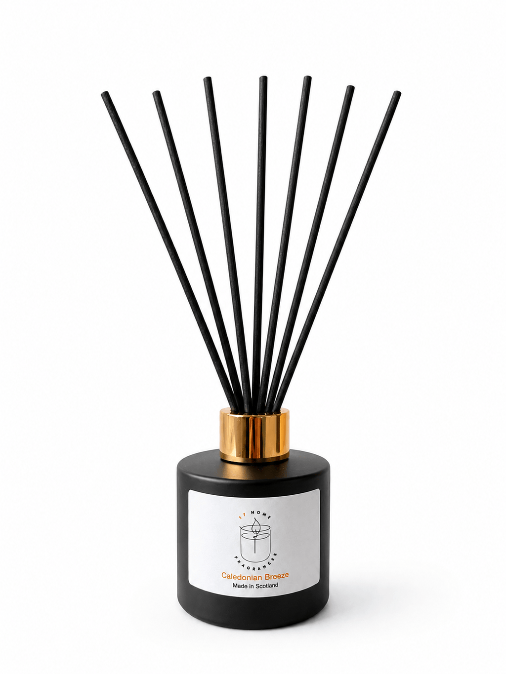 A reed diffuser bottle in matte black with a metallic gold collar and seven black reeds, featuring a white label with a candle icon and the text 'Caledonian Breeze' and 'Made in Scotland'.