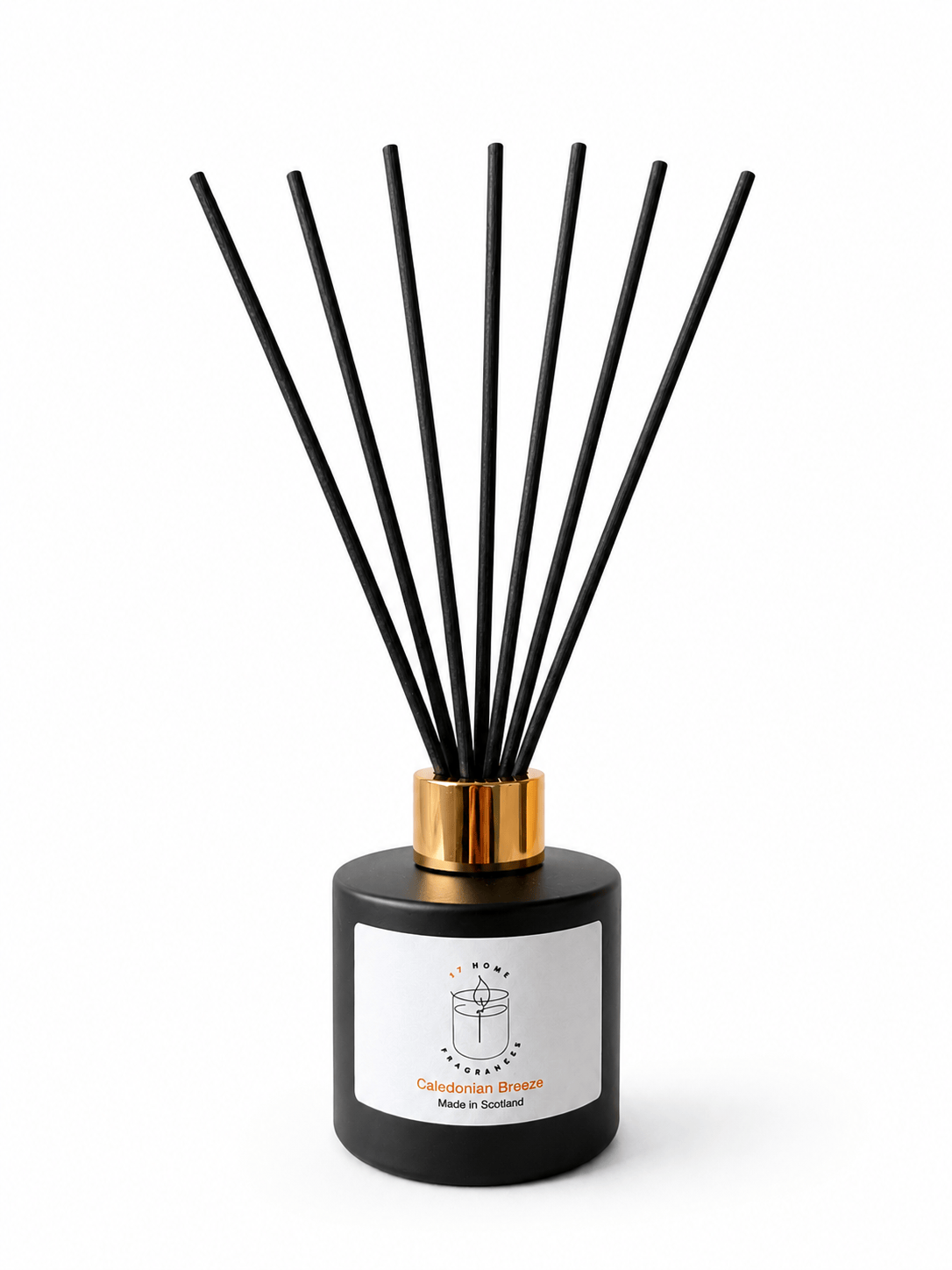 A reed diffuser bottle in matte black with a metallic gold collar and seven black reeds, featuring a white label with a candle icon and the text 'Caledonian Breeze' and 'Made in Scotland'.