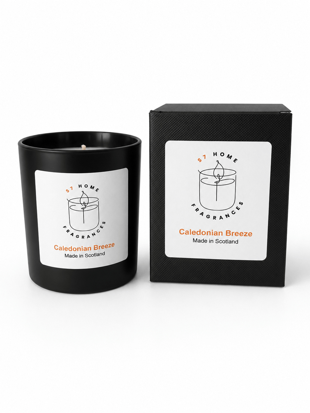A black candle jar with a white label next to its matching black box packaging, both featuring the brand 'S7 HOME Fragrances' and the scent name 'Caledonian Breeze'.