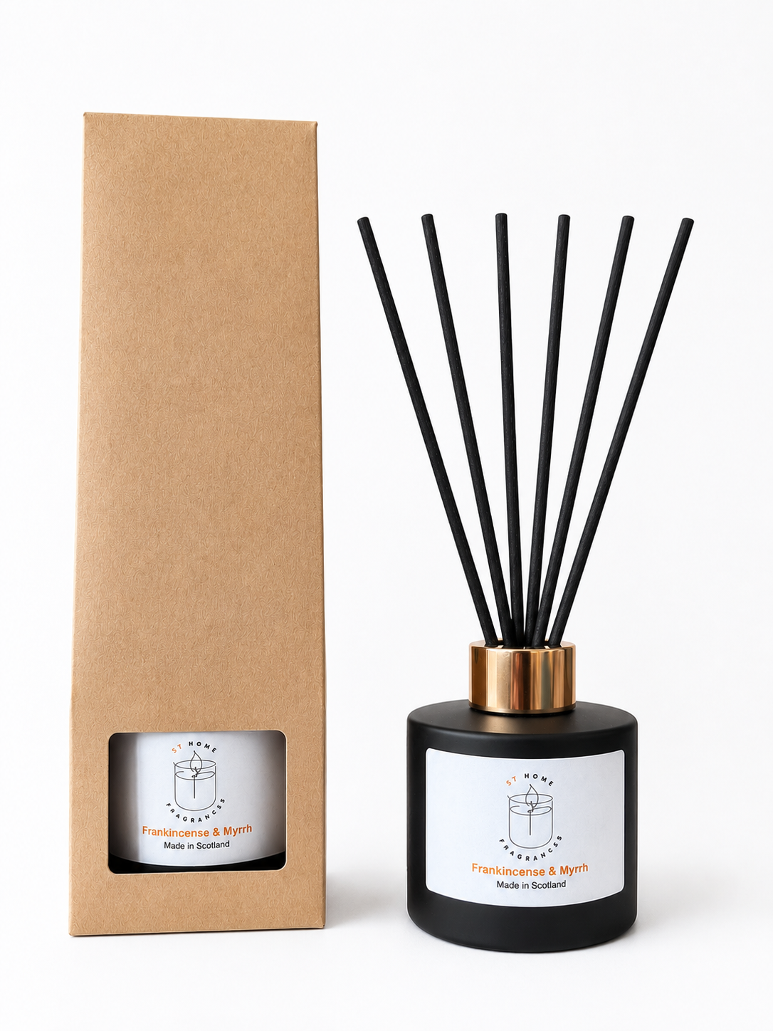 A reed diffuser bottle with black reeds and a black glass base next to its brown kraft paper packaging box, both featuring a white label with the brand name 'Frankincense & Myrrh and 'Made in Scotland'.