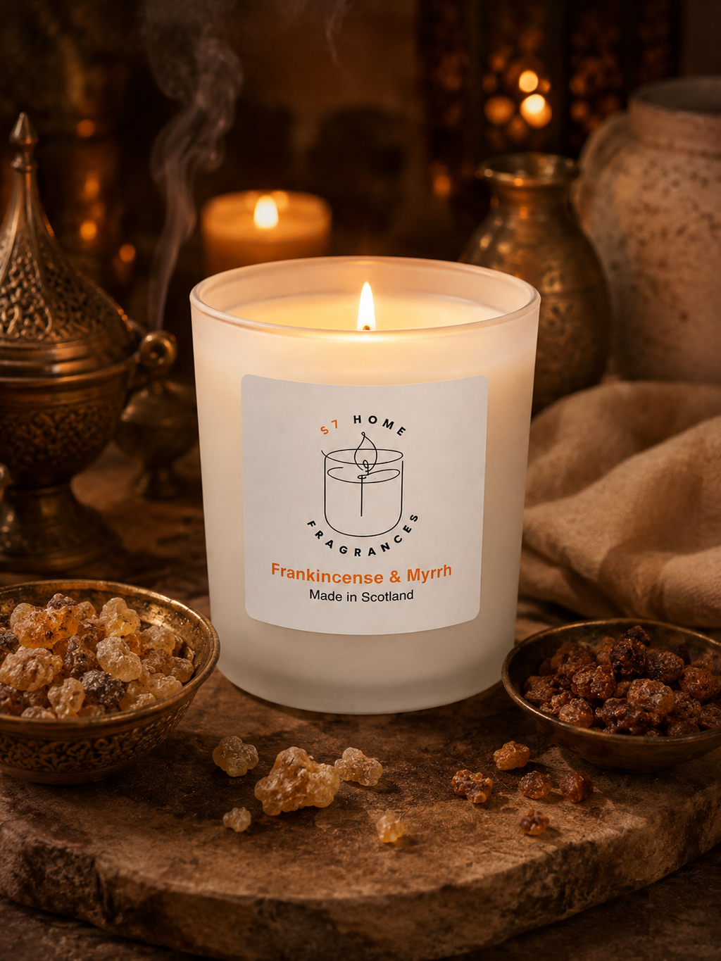 Frankincense & Myrrh candle with a label on a rustic surface with incense and a teapot.