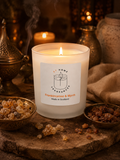 Frankincense & Myrrh candle with a label on a rustic surface with incense and a teapot.