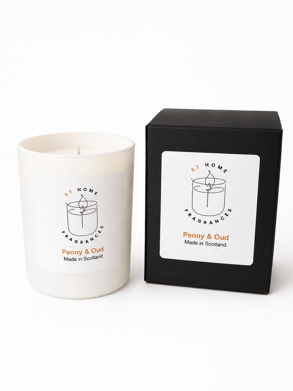 A white scented candle in a matte white glass vessel sits next to its black packaging box. Both feature a white label with a minimalist black line drawing of a candle and the text 'S7 HOME FRAGRANCES' and 'Peony & Oud Made in Scotland'.