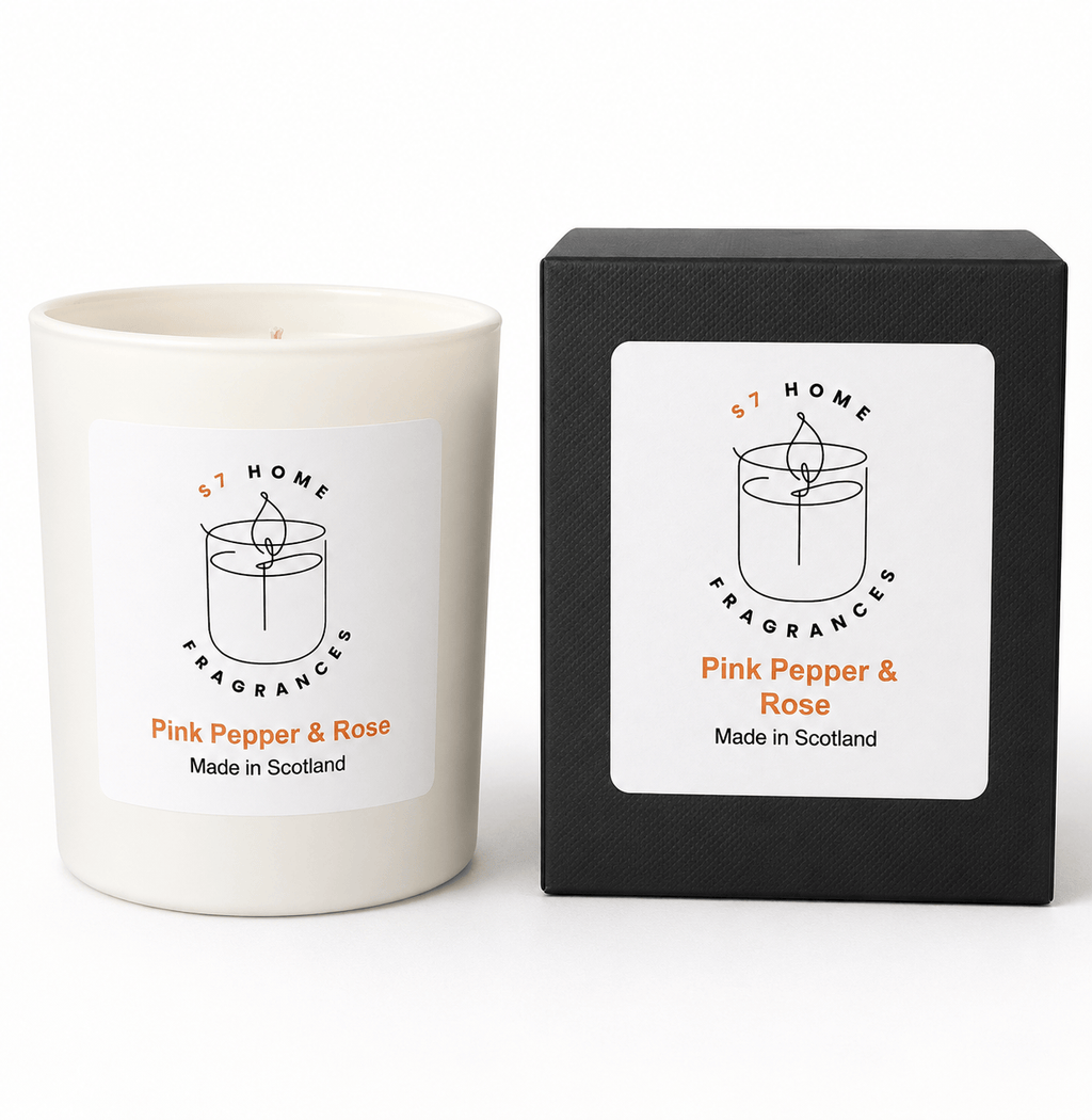 A white candle jar labeled 'S7 Home Fragrances Pink Pepper & Rose' stands next to its black textured packaging box on a clean white background.