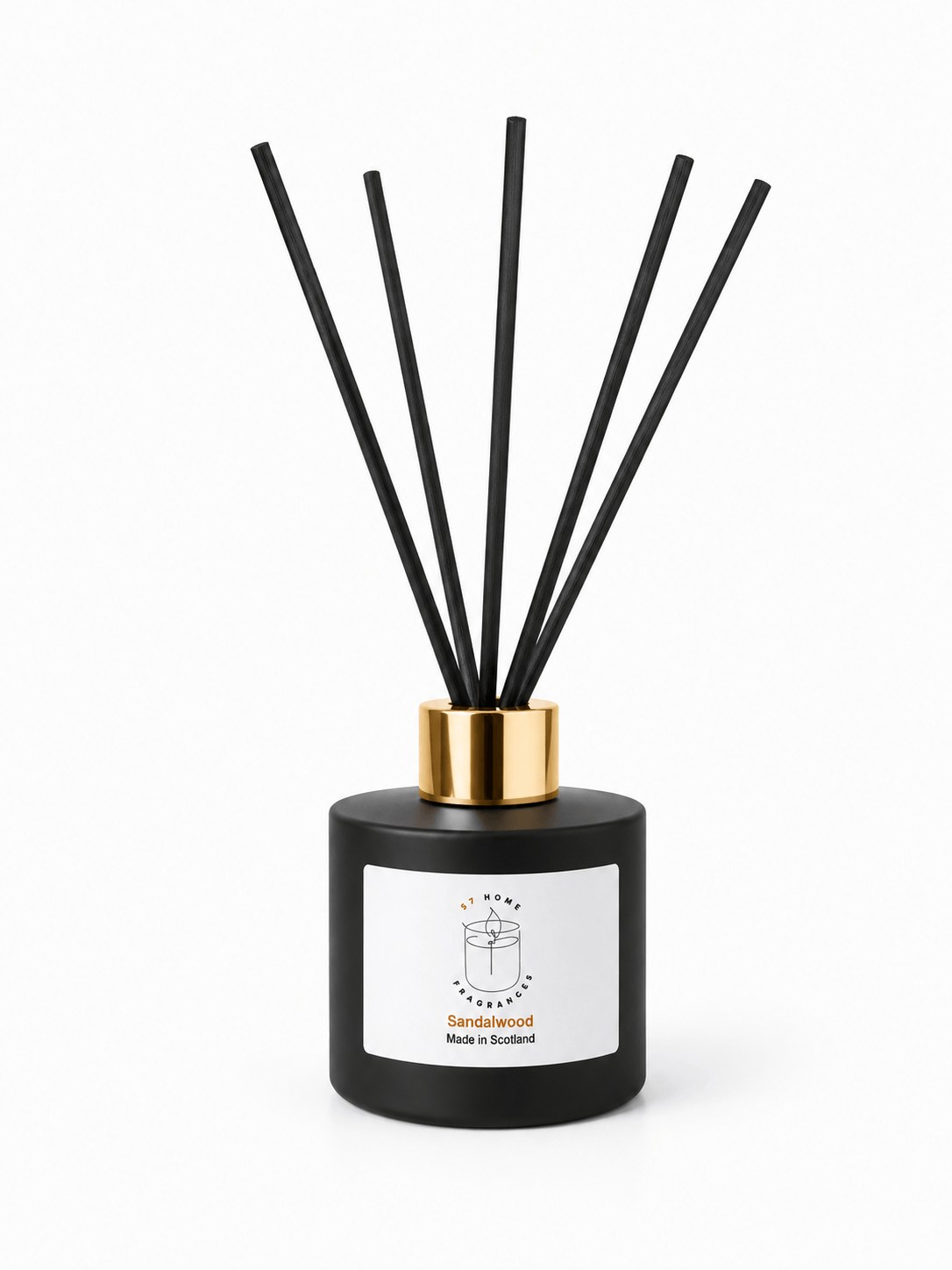 A reed diffuser bottle with a matte black cylindrical body, a gold collar, and six black reeds, featuring a white label with a simple line drawing and the text 'Sandalwood' and is 'Made in Scotland'.