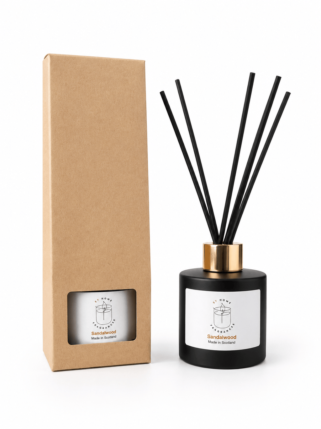 A reed diffuser bottle with black reeds, a black glass base, and a gold collar next to its tall brown kraft paper box on a white background.